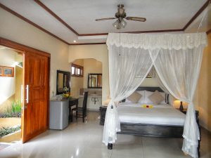 Phòng Deluxe tại Arya Beach Resort với giường đôi, nội thất trang nhã và ban công hướng vườn