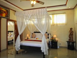 Suite gia đình tại Arya Beach Resort với không gian rộng rãi, phòng khách và ban công nhìn ra khu vườn xanh mát