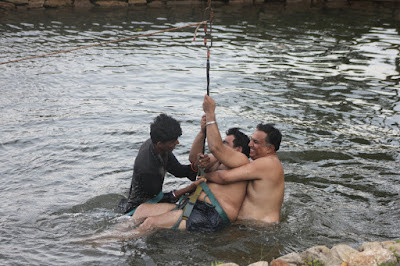 Nhân viên hỗ trợ tháo dây an toàn cho người chơi zipline