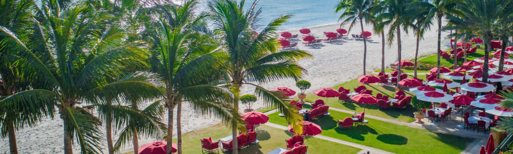 Acqualina Resort nhìn từ biển với bãi cát trắng và hàng dừa xanh mát
