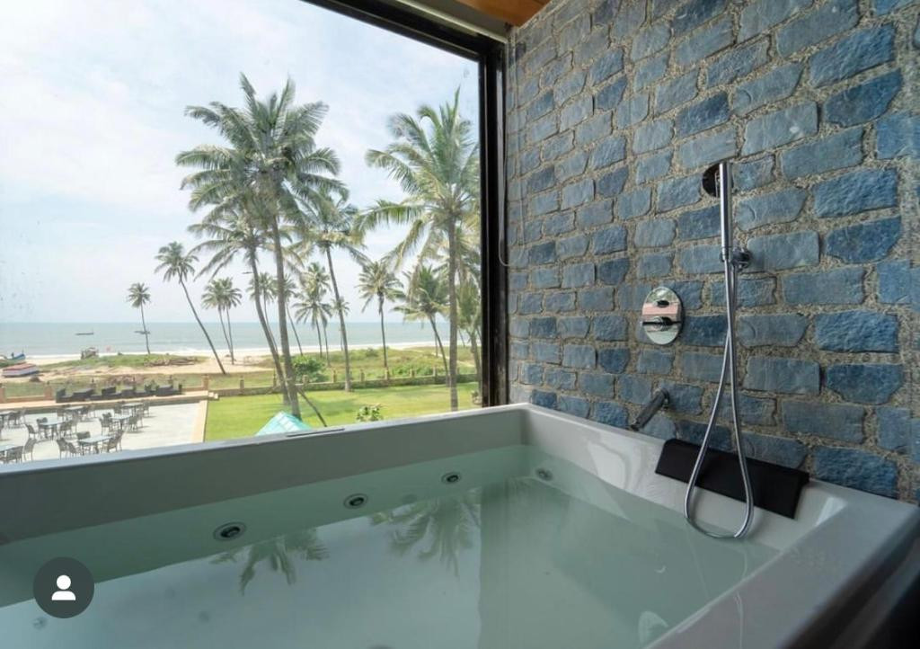 Phòng tắm jacuzzi riêng nhìn ra biển tại Longuinhos Beach Resort South Goa
