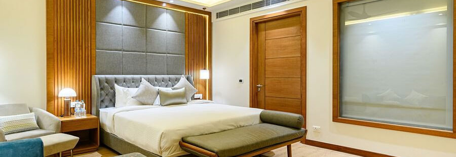 Interiors of one of the bedrooms at our presidential suite in Pushkar featuring a bed, a blue sofa and other furniture 5761