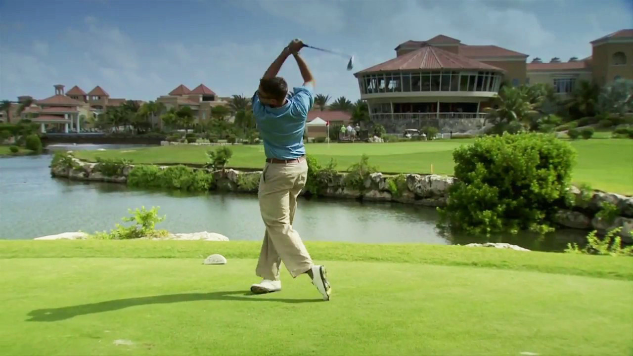 Khung cảnh một người chơi golf tại The Links, với clubhouse Divi phía sau