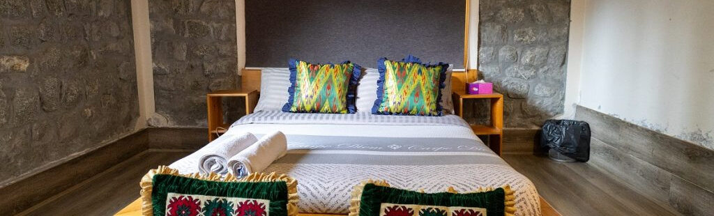 Phòng Deluxe Double Room tại Moksha Resort với giường cỡ King, nội thất sang trọng và ánh sáng ấm cúng
