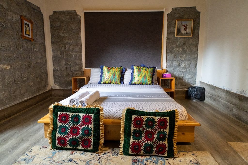 Phòng Deluxe Double Room tại Moksha Resort với giường cỡ King, nội thất sang trọng và ánh sáng ấm cúng