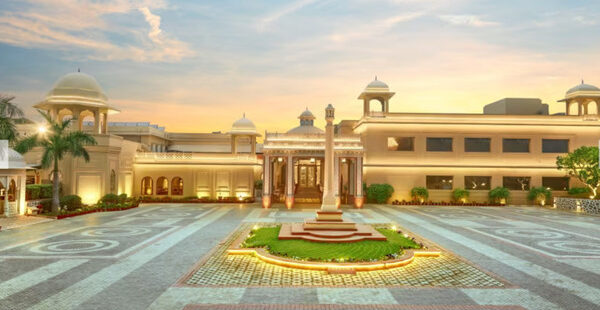 Heritage Village Resorts & Spa ở Manesar nhìn từ bên ngoài với kiến trúc kiểu làng quê và cây xanh tươi tốt