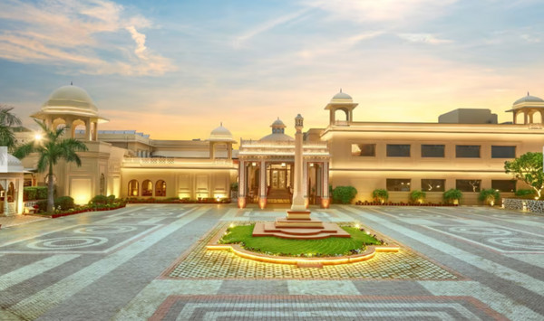 Heritage Village Resorts & Spa ở Manesar nhìn từ bên ngoài với kiến trúc kiểu làng quê và cây xanh tươi tốt