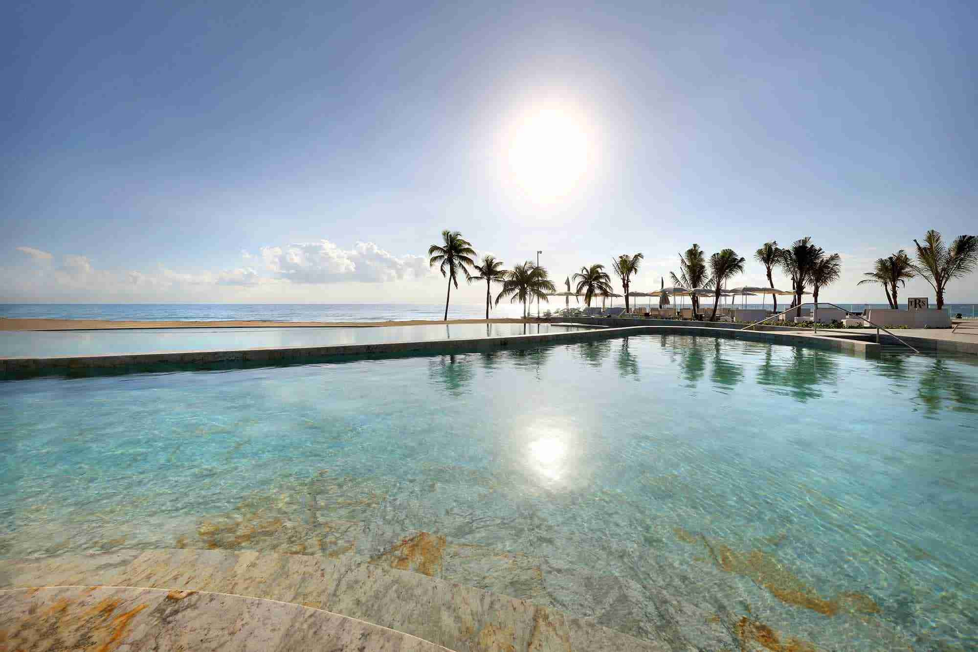 Hồ bơi chính tại TRS Yucatan Hotel với thiết kế hiện đại và tầm nhìn ra biển