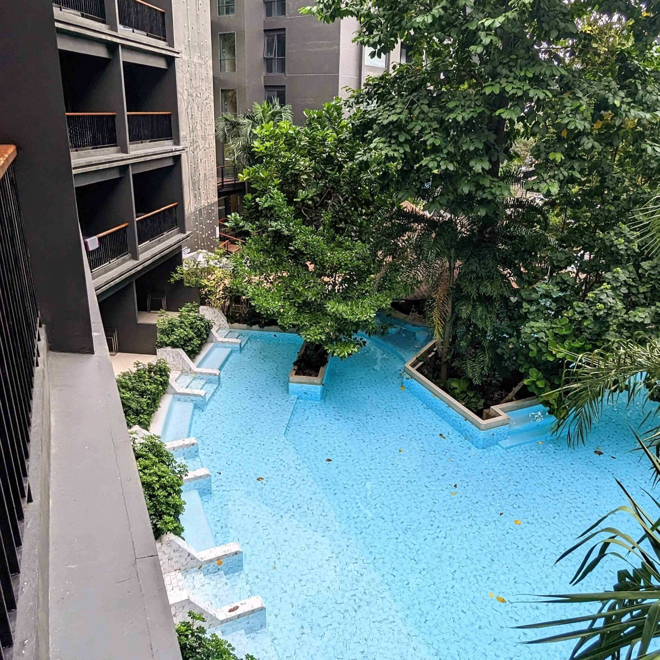 Tầm nhìn từ ban công phòng nghỉ ra hồ bơi và tường leo núi tại Panan Krabi Resort