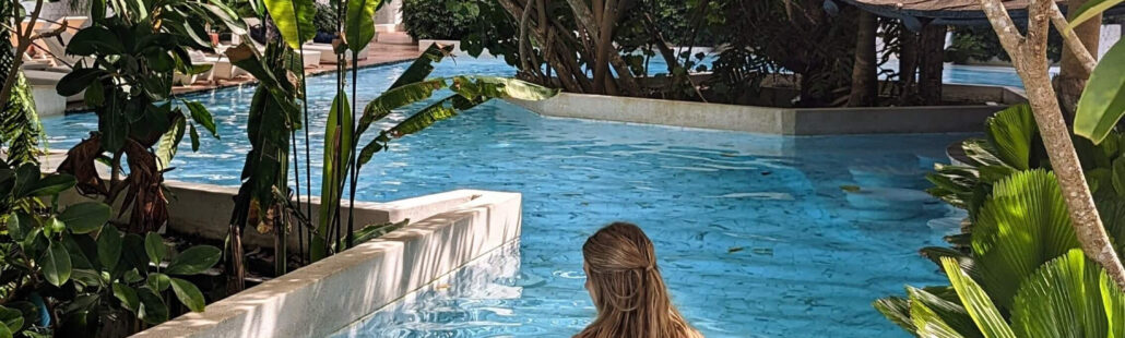 Hồ bơi với lối đi bộ bao quanh bởi cây xanh tại Panan Krabi Resort